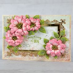 a card with pink flowers and green leaves