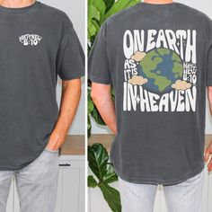 Men's On Earth As It Is In Heaven T-Shirt, Matthew 6:10, Comfort Colors Tees, Bible Verse Unisex Shirts MORE FROM OUR SHOP https://etchandinkco.etsy.com ABOUT OUR DESIGN Discover the perfect blend of style, comfort, and message that the "On Earth As It Is In Heaven" men's t-shirt provides. This message followed "Thy will be done" in the Lord's Prayer. Jesus taught His disciples to pray, "Our Father in heaven, hallowed be your name, your kingdom come, your will be done, on earth as it is in heaven" (Matthew 6:9-10). Jesus was committed to seeing God's will accomplished, and the prayer "Thy will be done" was a theme of His life. Is God's will the theme of your life too? May we all desire His will over our own. This shirt is unisex and would be a great addition to everyone's wardrobe. Ladies Casual Shirt With Graphic Print For Earth Day, Casual Graphic Print Shirt For Earth Day, Relaxed Fit Letter Print Tops For Earth Day, Earth Day Graphic Print Crew Neck Shirt, Casual Tops With Earth Day Screen Print, Casual Screen Print Tops For Earth Day, Earth Day Short Sleeve Top With Letter Print, Earth Day Letter Print Crew Neck Top, Letter Print Crew Neck Top For Earth Day