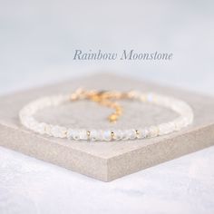 Beautiful natural Rainbow Moonstone gemstones are interspersed with your choice of tiny Gold Vermeil or Sterling Silver beads in this elegant bracelet. The Rainbow Moonstone beads are entirely natural and feature plenty of the mesmerising adularescence (blue flash) for which this gemstone is so loved. - Completely natural genuine gemstones measure approx. 3.5-4.5mm - Bracelet extends from 6.5-8 inches (custom sizes available on request) - Packaged in a gift box with gemstone information card ready for gifting or treating yourself - Choose from Gold Fill or 925 Sterling Silver The Rainbow Moonstone beads feature mesmerising blue flashes, and are a faceted rondelle shape with excellent sparkle. A birthstone for the month of June, Rainbow Moonstone is a magical looking stone, with internal gl Moonstone Gemstone Beaded Bracelet As Gift, Gold Beaded Bracelets With Moonstone, Minimalist Round Crystal Bracelet With Gemstone Beads, Gold Moonstone Bracelets With Natural Stones, Elegant Moonstone Healing Bracelet, Dainty White Gemstone Beads Bracelet, Delicate White Bracelets With Natural Stones, Delicate White Bracelet With Natural Stones, Elegant Crystal Bracelet With Gemstone Beads And Moonstone