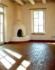 an empty room with brick floors and two windows