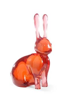 an orange glass rabbit figurine on a white background