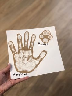 a person holding up a paper with a hand print on it