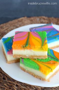 three slices of rainbow cheesecake on a white plate