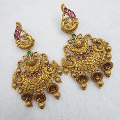 "These Jhumka Earrings set has an excellent finish and gives out an exquisite sense of style. If you are looking for an amazing Fashion Jewelry set for special occasions such as Anniversary, engagements, Party, Wedding or for gifting, then your search ends here. Handmade Indian Temple Jewelry, best to wear it for traditional ceremonies or Indian weddings. This bridal jewelry has ethnic finish. It has Cubic Zircon stones with ruby and emeralds. It is a Bollywood style one gram jewelry. There are Jeweled Chandbali Jhumkas For Celebration, Chandbali Jeweled Jhumkas For Celebration, Chandbali Jewelry With Peacock Design For Rituals, Chandbali Peacock Design Jewelry For Rituals, Ornate Tilla Earrings For Diwali, Festive Jhumkas With Peacock Design, Bridal Chandbali Earrings With Peacock Design For Festivals, Festival Bridal Chandbali Earrings With Peacock Design, Bridal Peacock Chandbali Earrings For Festivals