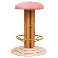 a bamboo stool with a pink cushion on it