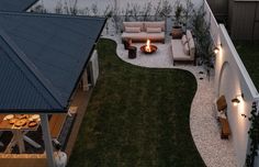 an aerial view of a backyard with fire pit and seating area in the evening time