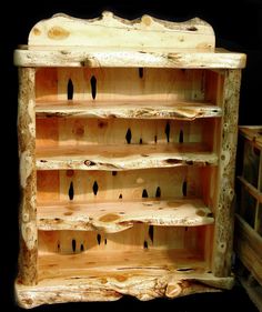 an old wooden shelf with many holes in it's bottom section and some black spots on the wood