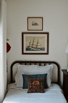 a bed with two pictures on the wall above it