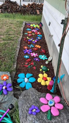 a garden with flowers and rocks in the ground next to a fence that reads, painting rock join share monze 1 d's no watering, need to fence for deer