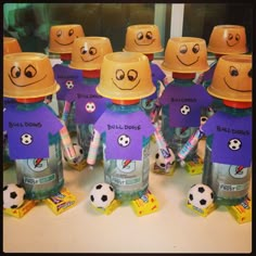 a group of children's bottles with faces drawn on them and soccer balls around them