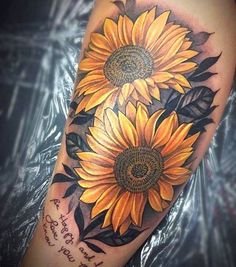 a sunflower tattoo on the arm with words written in it and two large yellow flowers