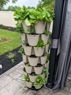 a tall planter filled with lots of green plants