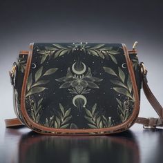 "Boho Forest witch Black Vegan leather saddle bag, women magic fern crossed body purse, cute PU leather hand bag goth bag, hippies boho gift This cute boho saddle Crossbody Bag is a great way to intrude Cottagecore styles into your everyday wardrobe. The purse is great for everyday use with an adjustable strap that can take it from Saddle bag style to Sling bag style. This vegan leather cute crossbody bag is just what you need for a little extra room for your stuff.  Made from quality materials Bohemian Crossbody Saddle Bag, Bohemian Crossbody Saddle Bag With Adjustable Strap, Bohemian Saddle Bag With Adjustable Crossbody Strap, Bohemian Crossbody Saddle Bag For Daily Use, Bohemian Satchel Saddle Bag With Adjustable Strap, Bohemian Saddle Bag Satchel With Adjustable Strap, Bohemian Shoulder Saddle Bag With Adjustable Strap, Goth Bag, Wolf Shifter