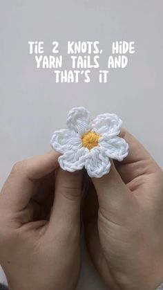 two hands holding a white crochet flower with the words tie 2 knots, hide yarn tails and that's it