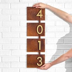 a person holding up a wooden sign with numbers on it