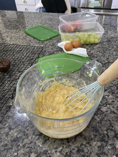 a glass bowl filled with batter on top of a counter next to other food items