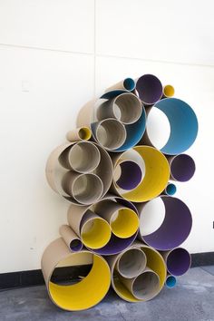 a stack of cups sitting on top of a floor next to a white wall in a room