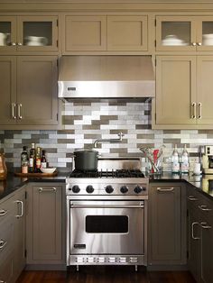 a kitchen with stainless steel appliances and wooden floors, gray cabinets and counter tops is seen in this image