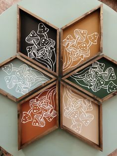 four wooden trays with designs on them are arranged in a hexagonal pattern