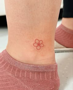 a small flower tattoo on the ankle