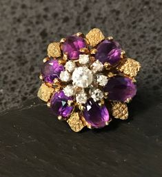 "Stunning large 14k layered Genuine Amethyst and white dazzling diamond statement ring.  Condition I see no problems, all stones prong set and present, tested for 14k gold,  Size 6 1/4, top of the ring is approx. 3/4\" in diameter, wt.- 8.2 grams-well designed with quality gems,  The white diamonds are set in white gold the rest of the ring is yellow gold, the center diamond is approx. 20 pts with 8-2 pt. diamonds surrounding it.  The oval genuine Amethyst are approx 11 by 5.5 mm.  the petal lik Vintage Purple Diamond Ring, Vintage Amethyst Ring With Diamond In Yellow Gold, Vintage Yellow Gold Amethyst Ring With Diamond, Purple Cluster Rings For Formal Occasions, Formal Purple Cluster Rings, Vintage Diamond Amethyst Ring For Anniversary, Vintage Amethyst Diamond Ring For Anniversary, Purple Cluster Ring For Anniversary In Fine Jewelry, Fine Jewelry Purple Cluster Ring For Anniversary