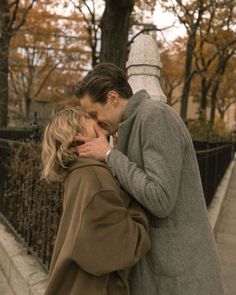 a man and woman kissing on the street