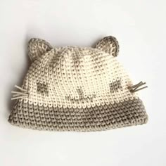 a knitted cat hat is laying on the floor with it's ears sticking out