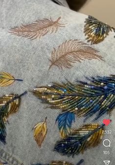 the back of a pair of jeans with colorful feathers on them and gold sequins