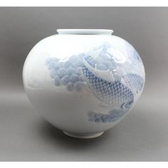 a white and blue vase with fish on it