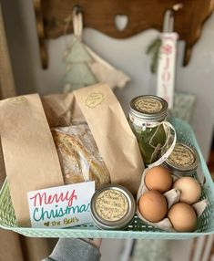 a basket filled with eggs, bread and jams sitting on top of a table