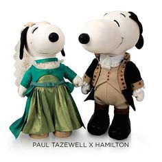 two stuffed animals dressed in costumes standing next to each other on a white surface with one holding the hand of another