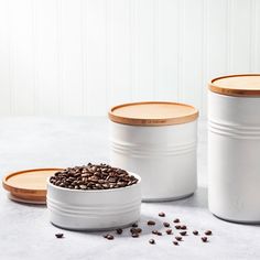 three white canisters filled with coffee beans