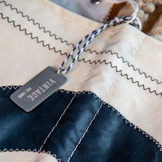 Zipper? ✔️ Interior pocket? ✔️ Unique Insignia? ✔️ Check out our collection of Deluxe Vintage Totes—beautiful examples of recycling at its finest. Each is one-of-a-kind and crafted here in our Maine shop. We include a special piece of sail hardware as an ornament for that extra touch of authenticity. Topped off with a zip closure and hand-spliced rope handles, it's a tribute to sailing and sustainability. Custom Homes, Sustainability, Maine, Recycling, Handles, Zipper