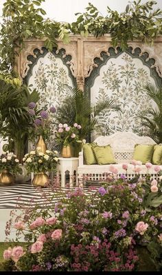 an outdoor seating area with potted plants and greenery on the walls, along with decorative wall panels