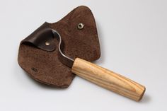 a leather tool case with a wooden handle and brown suede material on the inside