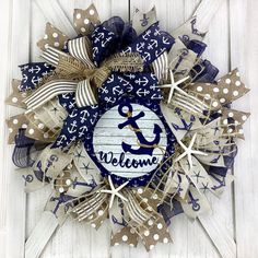 a blue and white wreath with an anchor, starfish and the word welcome on it