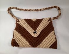 a brown and white purse with a button on it