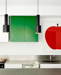 a kitchen with an apple painting on the wall