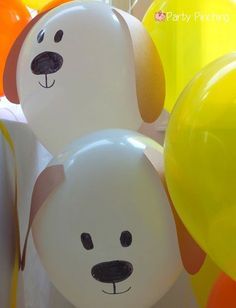 some balloons with faces on them are in the shape of dogs