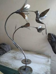 a metal bird sculpture sitting on top of a table