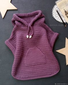 a crocheted purple sweater with a white heart on the chest and a star next to it