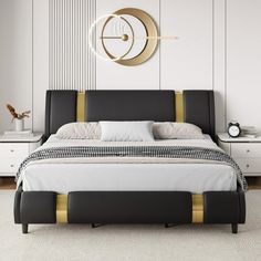 a modern bedroom with white walls and black bedding, gold trimming on the headboard