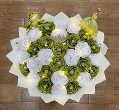 a bouquet made out of paper flowers with fairy lights on them and a frog figurine