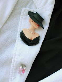 Elegant woman in black titfer hat. The brooch made of polymer clay. There are 3 ruby stones in a perfume bottle. This is my second C*co style brooch. Always stay beautiful and charming in your favorite clothes! Elegant Collectible Lapel Pin, Chic Brooch Jewelry For Parties, Chic Party Brooch Jewelry, Classic Evening Brooch, Chic Evening Jewelry Brooch, Chic Evening Brooch Jewelry, Chic Party Brooches, Chic Black Brooches For Parties, Handmade Elegant Formal Lapel Pin