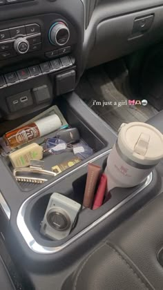 the interior of a car with various items in it and a cup on the dash