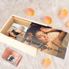 an open wooden box with two photos in it and some peaches on the ground