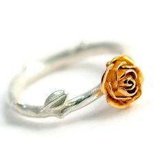 a gold rose ring sitting on top of a white surface