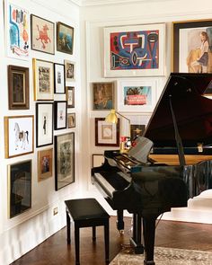 there is a piano in the room with many pictures on the wall