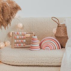 a white couch with toys on it in front of a basket and some lights behind it