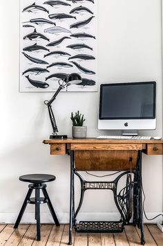 an old sewing machine sits in front of a desk with a computer on it